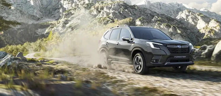 Subaru Forester Híbrida, sobre terreno arenoso con montaña de fondo.