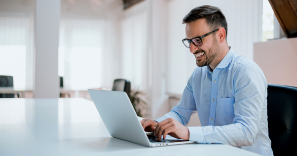 Hombre sonriente viendo su computador