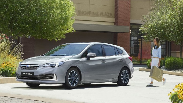 Subaru New Impreza aparcado en casa familiar, y al lado una señora dirigiéndose a abrirlo